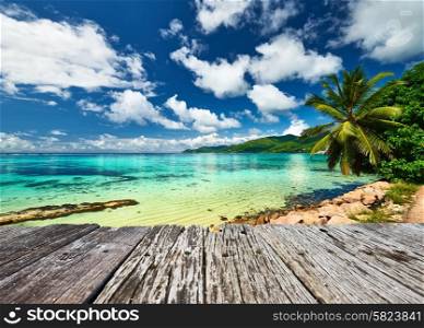 Beautiful beach and old wooden pier with palm tree at Seychelles, Mahe