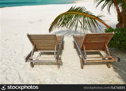 Beautiful beach at Maldives with chaise-lounges