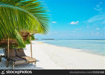Beautiful beach at Maldives with chaise-lounges