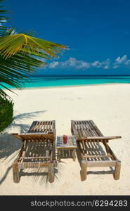 Beautiful beach at Maldives with chaise-lounges