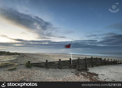 Beautiful beach coastal landscape image at sunrise with colorful vibrant sky