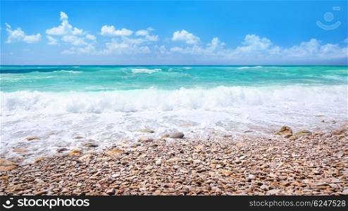 Beautiful beach panorama, amazing landscape of a stony seaside, refreshing clear blue water, summer vacation on a tropical resort