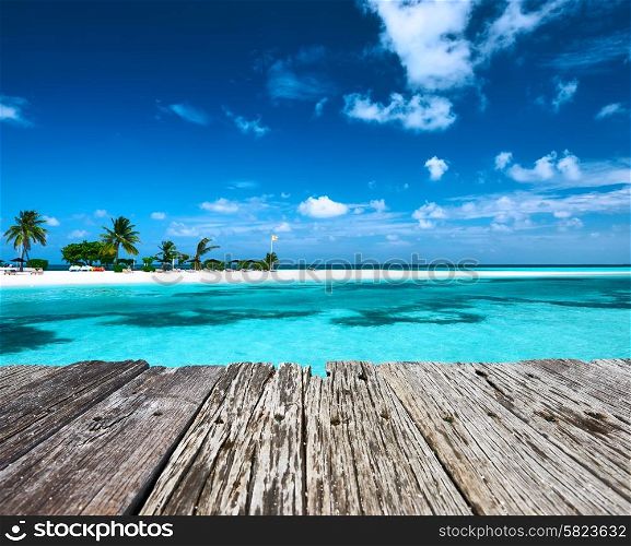 Beautiful beach with sandspit and old wooden pier at Maldives