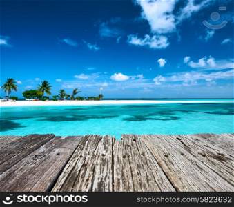 Beautiful beach with sandspit and old wooden pier at Maldives
