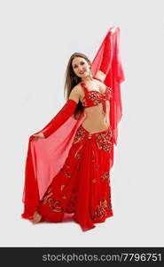 Beautiful belly dancer in red outfit holding veil, isolated