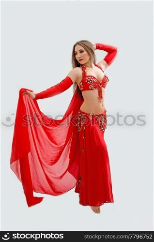 Beautiful belly dancer in red outfit holding veil, isolated