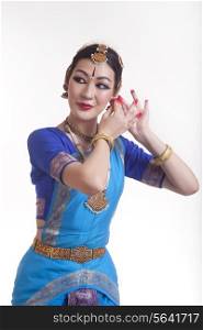 Beautiful Bharat Natyam dancer performing over white background