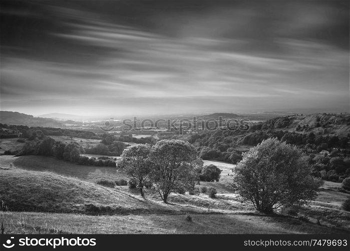Beautiful black and white landscape image of view over English countryside during Summer sunset