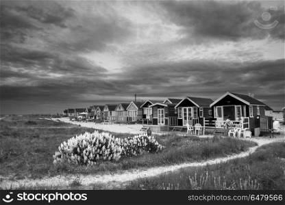Beautiful black and white landscape of dramatic stormy sky over . Landscapes. Black and white landscape of dramatic stormy sky over beach huts in grassy dunes