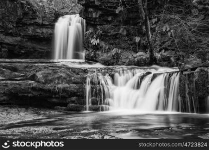 Beautiful black and white waterfall landscape image in forest during Autumn Fall
