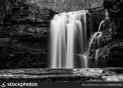 Beautiful black and white waterfall landscape image in forest during Autumn Fall