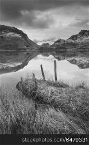 Beautiful black and white Winter landscape image of Llyn Nantll. Beautiful black and white sunrise landscape image in Winter of Llyn Nantlle in Snowdonia National Park with snow capped mountains in background