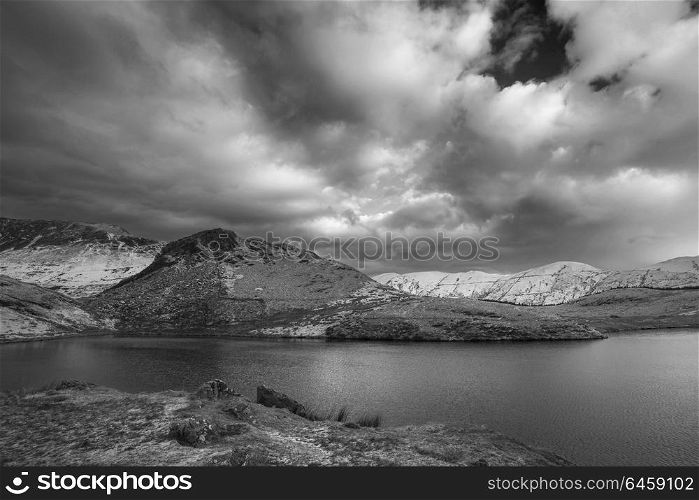 Beautiful black and white Winter landscape image of Llyn y Dywarchen in Snowdonia National Park