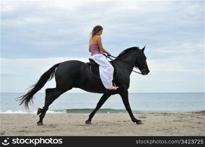 beautiful black horse on the beach and beautiful woman