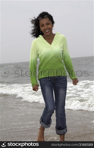 beautiful black woman happily strolling along the seaside