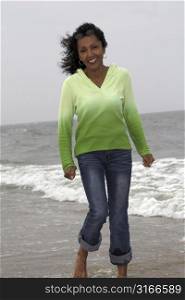 beautiful black woman happily strolling along the seaside
