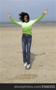 Beautiful black woman jumping on the beach
