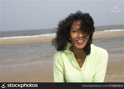 Beautiful black woman outdoors by the sea on a windy day