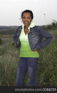 Beautiful black woman standing in front of a dune-scene