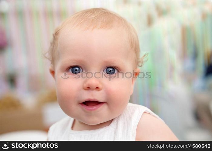 Beautiful blond baby with blue eyes smiling
