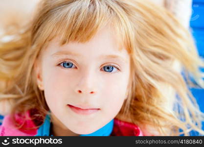 Beautiful blond blue eyes girl lying closeup face