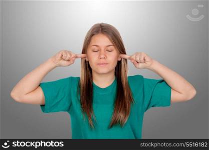 Beautiful blond girl covering the ears isolated on grey background