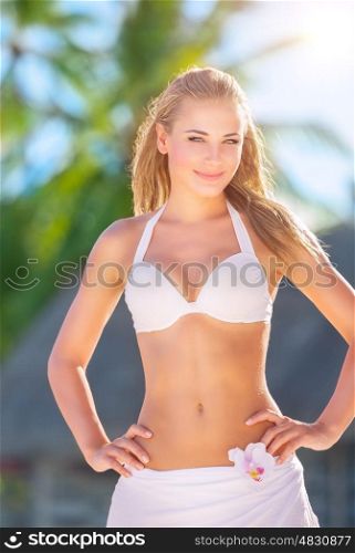 Beautiful blond girl spending time on the beach, having fun outdoors in bright sunny day, summer holidays and vacation concept