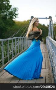 beautiful blond girl standing on the bridge in the park. autumn scene