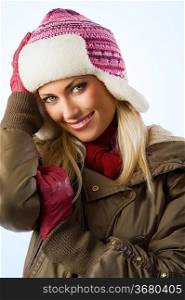 beautiful blond girl wearing a winter breakwind jacket scarf gloves and pink hat