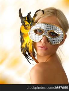 beautiful blond girl with glitter silver mask and yellow feather