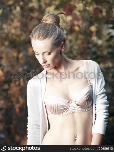 Beautiful blond lady in lingerie at a natural background of leaves