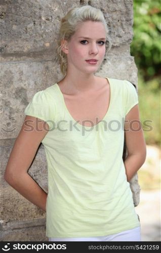 Beautiful blond leaning on a wall.