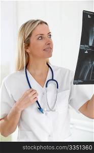 Beautiful blond nurse looking at X-ray