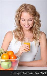 Beautiful blond woman drinking fruit juice