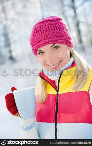 Beautiful blond woman drinking hot tea outdoors