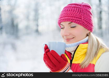 Beautiful blond woman drinking hot tea outdoors