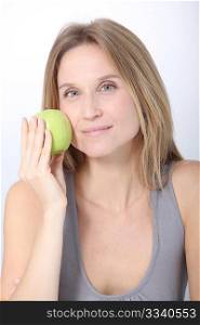 Beautiful blond woman eating green apple
