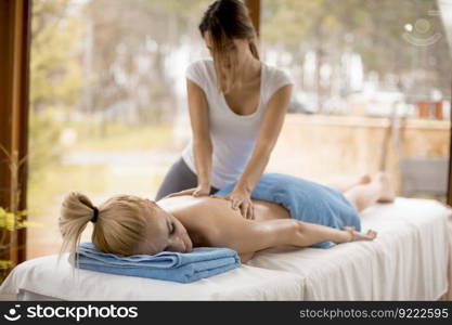 Beautiful blond woman enjoying a massage at the health spa