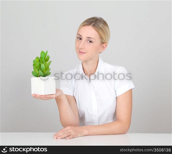 Beautiful blond woman holding plant pot