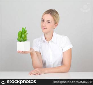 Beautiful blond woman holding plant pot