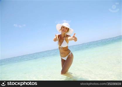 Beautiful blond woman in bikini showing thumbs up