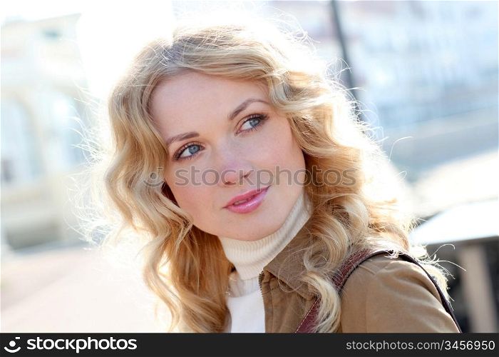 Beautiful blond woman in town by sunny day