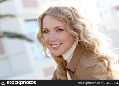 Beautiful blond woman in town by sunny day