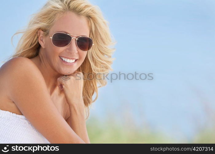 Beautiful Blond Woman in White Dress and Sunglasses At Beach