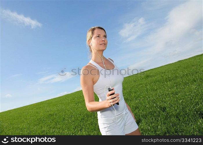 Beautiful blond woman jogging in country field
