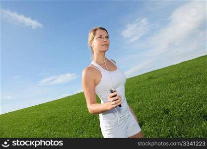 Beautiful blond woman jogging in country field
