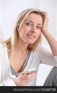 Beautiful blond woman listening to music