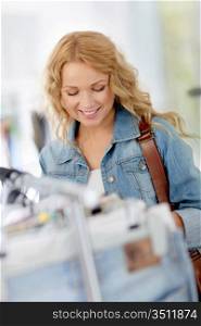 Beautiful blond woman looking at price tags in store