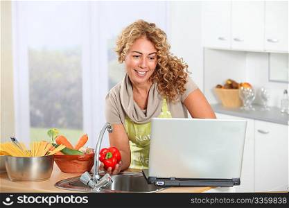 Beautiful blond woman looking at recipe on internet