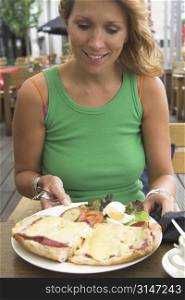 Beautiful blond woman looking very happy to receive a plate full of tasty food